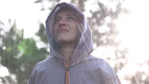 un homme sous la pluie protégé par un poncho