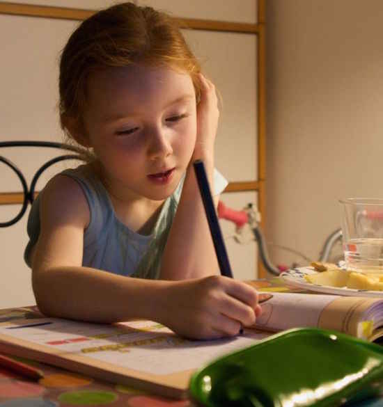 Petite fille studieuse qui fait ses devoirs