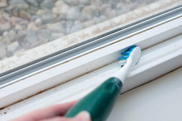 Use an old toothbrush to clean window tracks.