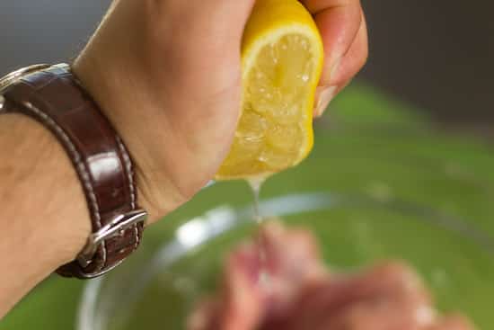 En train de mettre du jus de citron sur la viande