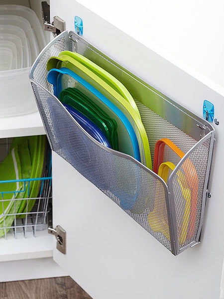 des couvercles de tupperware rangés dans des porte-revues en métal