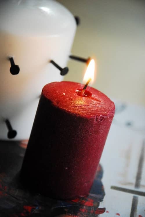 Tuto pour faire une bougie pleine de sang pour Halloween avec une bougie blanche, des clous et une bougie rouge