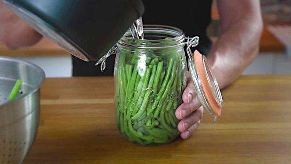 des légumes sont mis en conserve dans des bocaux en verre
